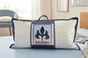 A pillow in its packaging is placed on a bed. Produktbild-Vorschau