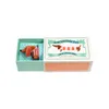 A small plush dachshund toy is presented in an open box, resembling a matchbox. Produktbild-Vorschau