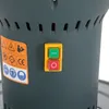 A close-up view of the control panel and warning labels on a dark gray cylindrical machine. Náhled obrázku produktu