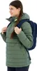 A young woman wearing a green puffer jacket and a blue backpack. Náhled obrázku produktu