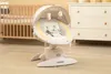 A baby swing chair is placed on a carpeted floor in a nursery, with a crib and a dresser in the background. Anteprima dell’immagine prodotto