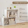 A white, 3-tiered shelf unit displaying books, decorative items, headphones, and a basket. Anteprima dell’immagine prodotto
