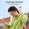 A woman wearing earbuds and a green hoodie is dancing outdoors. Produktbild-Vorschau