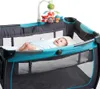 A baby lying in a playpen with a mobile above. Voir les images du produit