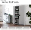 An open metal cabinet filled with binders, placed in a room with a brick wall and a smaller cabinet to the left. Produktbild-Vorschau