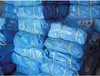 A stack of blue tarps bundled together with yellow straps. Produktbild-Vorschau