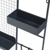A close-up view of a black metal wall grid with two black planters attached. Produktbild-Vorschau