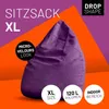 A purple beanbag chair is shown against a vibrant orange and purple background, with text overlays highlighting its features. Produktbild-Vorschau