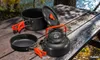 Camping cookware set on a wooden picnic table near a body of water. Náhled obrázku produktu