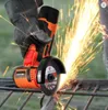 A close-up shot of a person using a cordless angle grinder to cut metal, with sparks flying. Podgląd zdjęcia produktu