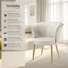 A white velvet armchair with gold legs is shown in a well-lit room with sheer curtains in the background. A text overlay on the left describes the product's features. Produktbild-Vorschau
