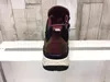 The back view of a women's hiking boot is displayed on a white shelf against a wood-paneled background. Produktbild-Vorschau