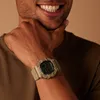 A man's wrist wearing a tan digital watch. Podgląd zdjęcia produktu