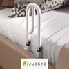 A close-up view of a white bed rail attached to a bed. Náhled obrázku produktu