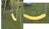 A yellow swing seat hanging from a wooden swing set in a grassy yard. Produktbild-Vorschau