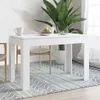 A white dining table is shown in a bright room with a large plant and chairs. Produktbild-Vorschau