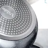 Close-up view of the bottom of a black frying pan with a speckled finish and a silver metallic base with a pattern of raised dots. The brand name 'Vilde' is visible in an oval emblem on the base. Produktbild-Vorschau