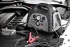 A portable power station is placed on top of a car engine, connected by jumper cables. Podgląd zdjęcia produktu