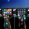 Two car infotainment screens are shown, one displaying Apple CarPlay and the other Android Auto, with app icons flowing from the screens to smartphones held below. Podgląd zdjęcia produktu