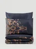 A folded duvet cover and pillowcase set with a dark blue background and ornate gold pattern. Podgląd zdjęcia produktu