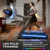 A man is running on a treadmill in a modern living room. Produktbild-Vorschau