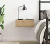 A bedside table with a lamp and a cup of coffee next to a bed. Náhled obrázku produktu