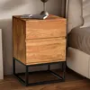 A wooden nightstand with two drawers and a black metal frame is placed next to a bed. Anteprima dell’immagine prodotto