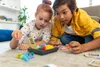Two children are playing a board game on the floor. Produktbild-Vorschau