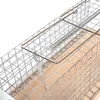 Close-up view of a metal wire cage trap with a wooden base and a spring mechanism. Produktbild-Vorschau