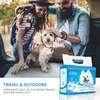 A couple and their dog are in the back of a car, with a package of pet pads in the foreground. Produktbild-Vorschau