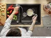 A person is using a kitchen faucet with a spray nozzle to rinse rice in a colander in a sink. Vegetables are prepared on a cutting board next to the sink. Produktbild-Vorschau