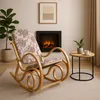 A rocking chair is placed in a living room setting next to a fireplace and a small side table. Podgląd zdjęcia produktu