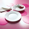 Two white plates are arranged on a pink surface, with a white napkin and some red berries and greenery on one plate. Anteprima dell’immagine prodotto