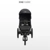 A black stroller is shown from the front against a white background. Náhled obrázku produktu