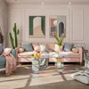 A living room scene with a pink couch, a blue armchair, and a transparent coffee table. Anteprima dell’immagine prodotto