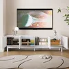 A white TV stand with open doors, displaying books, decorative boxes, and a basket, with a television mounted on the wall above it. Anteprima dell’immagine prodotto