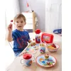 A young boy is sitting at a table with a HABA plate and other tableware. Voir les images du produit