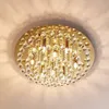 A close-up view of a gold-colored ceiling light fixture with multiple crystal strands hanging from a circular base. Produktbild-Vorschau