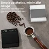 A flat lay of coffee-related items including two digital scales, coffee beans, and a portafilter. Produktbild-Vorschau