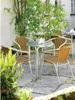 An outdoor cafe setting with a round table and chairs. Produktbild-Vorschau