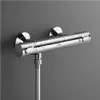 A chrome shower thermostat mounted on a gray wall, with water droplets on its surface. Náhľad obrázku produktu