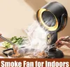 A smoke fan is placed behind a hot pot, with people using chopsticks to cook food in the pot. Steam rises from the pot and is being drawn towards the fan. Produktbild-Vorschau