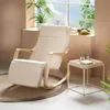 A rocking chair and side table are placed near a window with plants and fruit on the windowsill. Produktbild-Vorschau