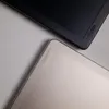 Close-up view of two laptop cases, one black and one silver, angled towards each other. Produktbild-Vorschau