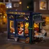 A miniature model of a tea room shop at night, with warm interior lighting. Produktbild-Vorschau