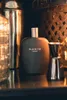 A black perfume bottle labeled 'BLACK TIE FOR MEN' is displayed on a dark surface, with a cocktail shaker and jigger in the background. Voir les images du produit