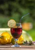 A drink with lemon and other fruits on a wooden table outdoors. Podgląd zdjęcia produktu