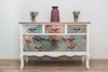 A dresser with a marble-patterned front, decorated with plants and a vase on top, against a white wall. Náhľad obrázku produktu