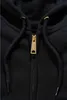 A close-up view of the zipper and drawstrings of a black hooded jacket. Anteprima dell’immagine prodotto
