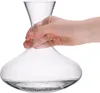 A hand holding a glass decanter with cleaning beads at the bottom. Anteprima dell’immagine prodotto
